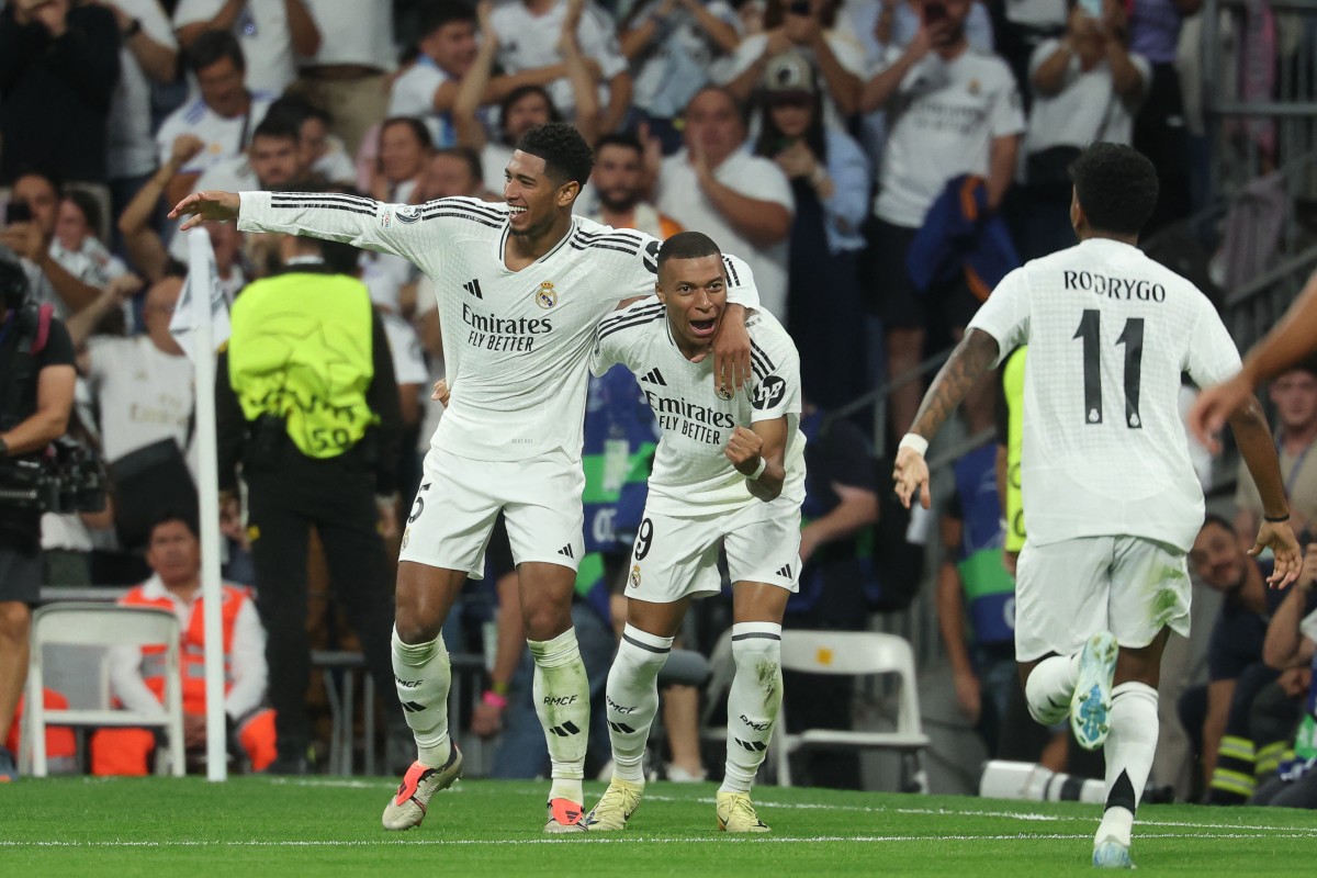 Real Madrid's French forward #09 Kylian Mbappe celebrates with Real Madrid's English midfielder #05 Jude Bellingham and Real Madrid's Brazilian forward #11 Rodrygo after scoring his team's first goal during the UEFA Champions League 1st round day 1 football match between Real Madrid CF and Stuttgart VFB at the Santiago Bernabeu stadium in Madrid on September 17, 2024. (Photo by Pierre-Philippe MARCOU / AFP)